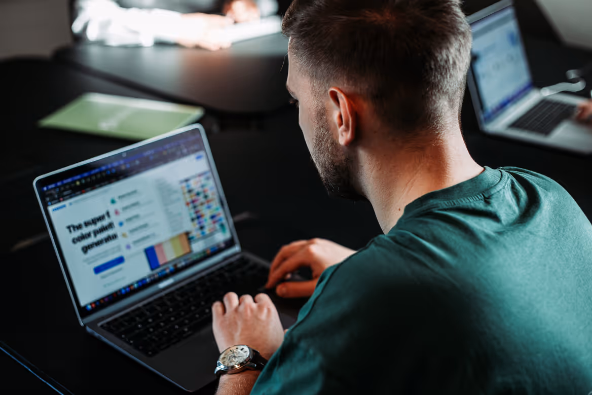 Designer am Laptop bei der Arbeit an einer Farbpalette