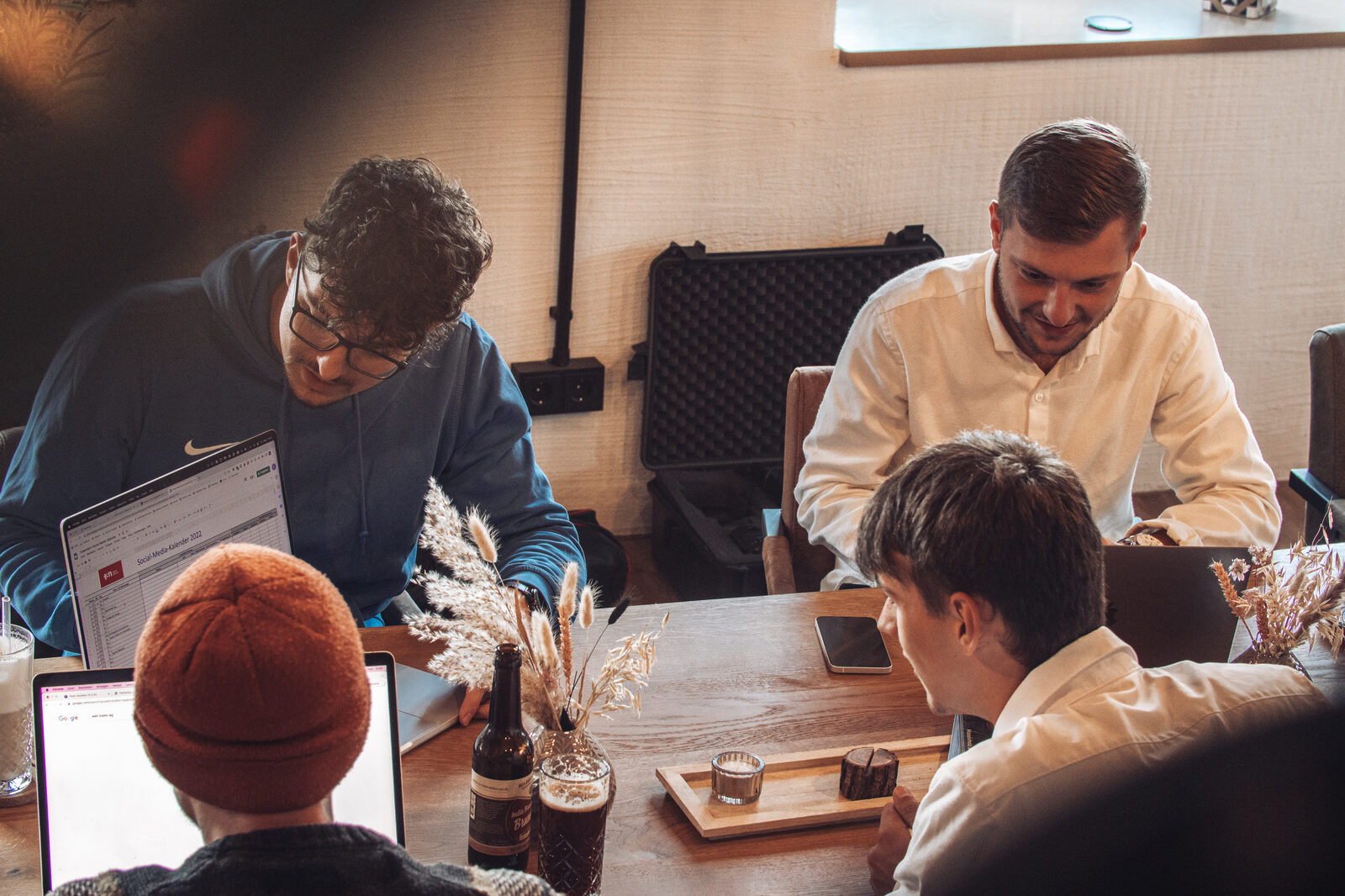 Greenstein Team konzentriert an einem warmen Holztisch bei Kerzenlicht