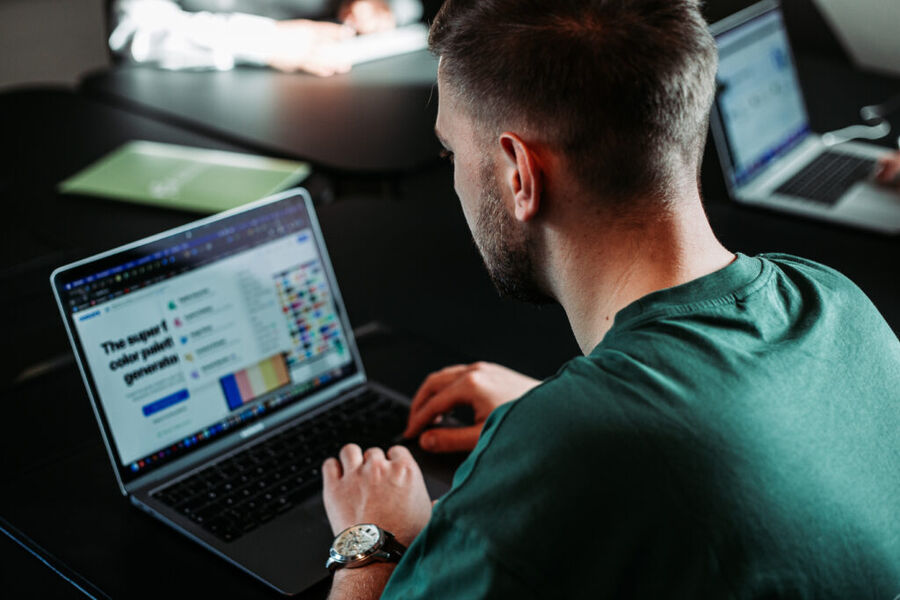 Person arbeitet am Laptop in Büro.